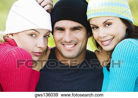 Portrait of a mid adult man and two young women smiling View Large Photo Image Stock Photo - Portrait of a mid adult man and two young women smiling. Fotosearch