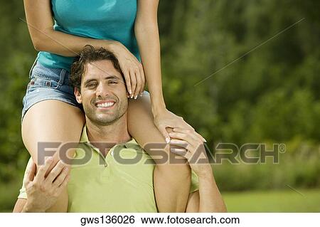 Portrait of a mid adult man carrying a young woman on his shoulders View Large Photo Image Stock Photograph - Portrait of a mid adult man carrying a young woman on his shoulders. Fotosearch