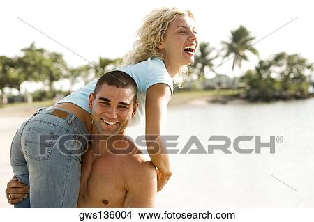Portrait of a young man carrying a young woman on his shoulders View Large Photo Image Picture - Portrait of a young man carrying a young woman on his shoulders. Fotosearch