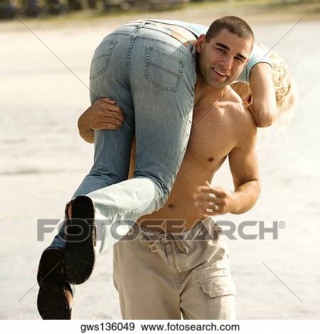 Portrait of a young man carrying a young woman on his shoulders View Large Photo Image Stock Photo - Portrait of a young man carrying a young woman on his shoulders. Fotosearch