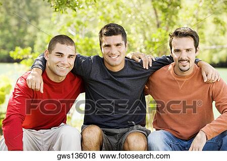 Portrait of three friends sitting and smiling View Large Photo Image Stock Photo - Portrait of three friends sitting and smiling. Fotosearch