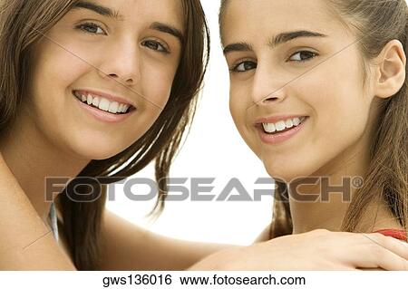 Stock Photograph - Portrait of two teenage girls hugging each other. Fotosearch