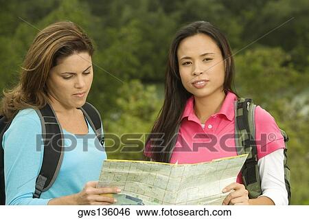 Portrait of two young women looking at a map View Large Photo Image Stock Photograph - Portrait of two young women looking at a map. Fotosearch