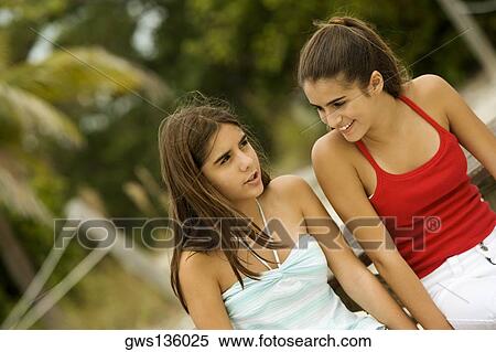 Stock Photography - Two teenage girls sitting together smiling. Fotosearch