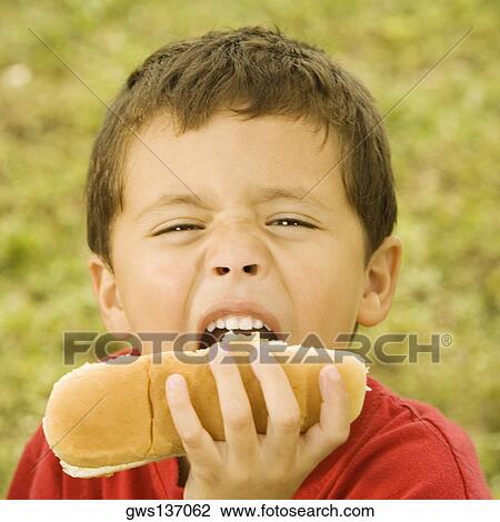 Close-up of a boy eating a hot dog View Large Photo Image Stock Image - Close-up of a boy eating a hot dog. Fotosearch