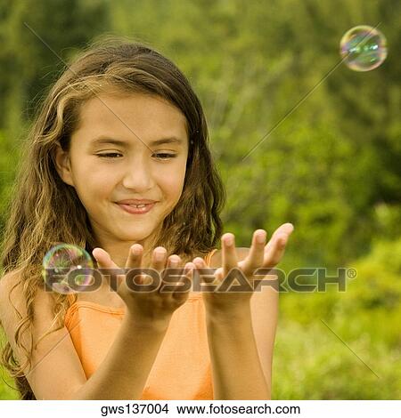 Close-up of a girl catching bubbles View Large Photo Image Picture - Close-up of a girl catching bubbles. Fotosearch