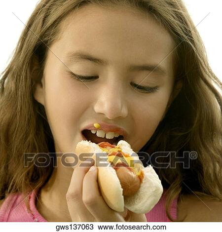 Stock Image - Close-up of a girl eating a hot dog. Fotosearch