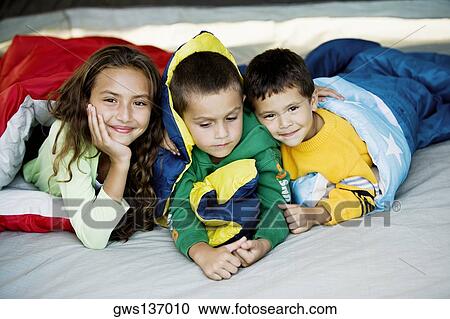 Close-up of a sister and her two brothers lying on the bed View Large Photo Image Stock Image - Close-up of a sister and her two brothers lying on the bed. Fotosearch