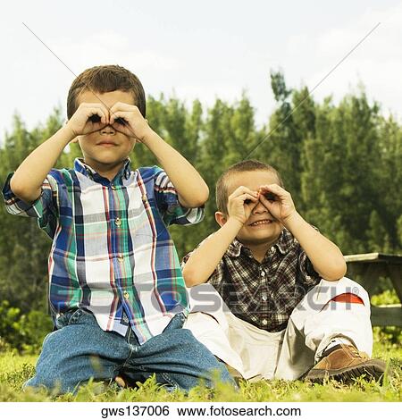 Close-up of two boys looking through their hands View Large Photo Image Stock Photograph - Close-up of two boys looking through their hands. Fotosearch