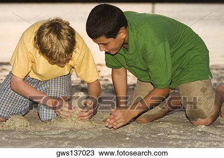 Close-up of two brothers playing in sand View Large Photo Image Stock Image - Close-up of two brothers playing in sand. Fotosearch