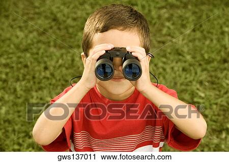 High angle view of a boy looking through a pair of binoculars View Large Photo Image Stock Image - High angle view of a boy looking through a pair of binoculars. Fotosearch