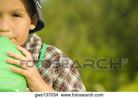 Portrait of a boy drinking water View Large Photo Image Picture - Portrait of a boy drinking water. Fotosearch