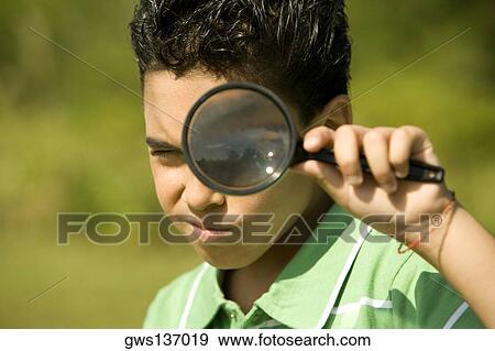 Portrait of a boy looking through a magnifying glass View Large Photo Image Stock Photo - Portrait of a boy looking through a magnifying glass. Fotosearch