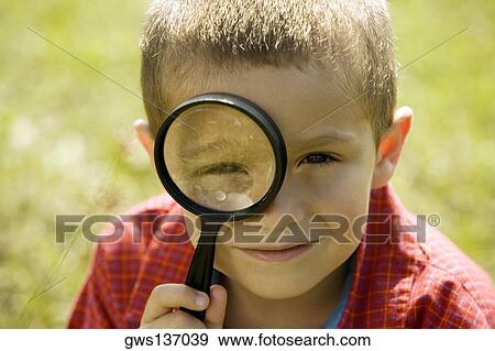 Stock Photo - Portrait of a boy looking through a magnifying glass. Fotosearch