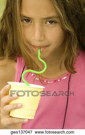Stock Photo - Portrait of a girl drinking from a straw. Fotosearch