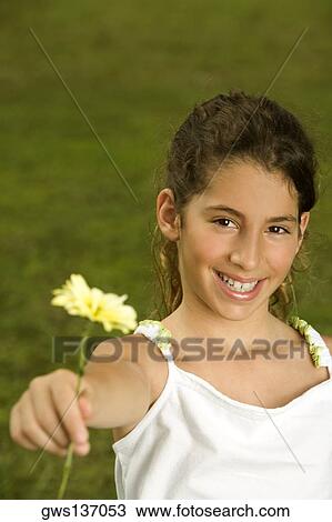 Portrait of a girl holding a flower View Large Photo Image Stock Image - Portrait of a girl holding a flower. Fotosearch
