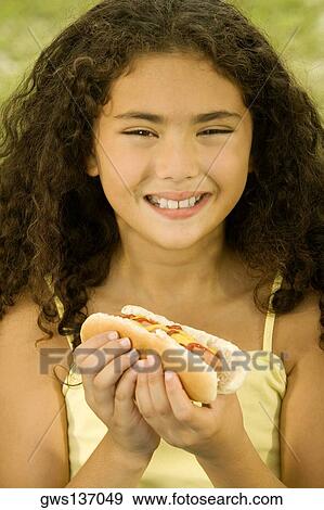 Stock Photo - Portrait of a girl holding a sandwich. Fotosearch