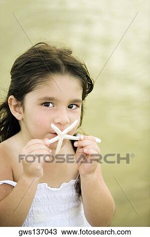 Portrait of a girl holding a starfish View Large Photo Image Stock Image - Portrait of a girl holding a starfish. Fotosearch