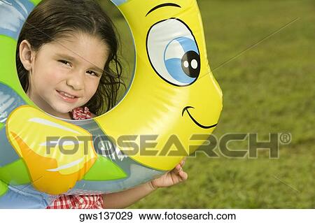 Stock Photo - Portrait of a girl looking through an inflatable ring. Fotosearch