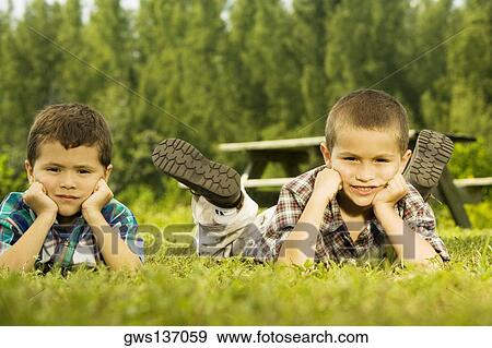 Portrait of two boys lying on the lawn View Large Photo Image Stock Photo - Portrait of two boys lying on the lawn. Fotosearch