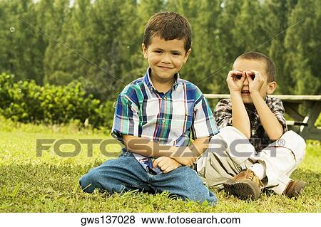 Portrait of two boys sitting on the lawn View Large Photo Image Stock Photo - Portrait of two boys sitting on the lawn. Fotosearch