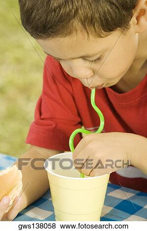 Close-up of a boy drinking with a drinking straw View Large Photo Image Stock Photo - Close-up of a boy drinking with a drinking straw. Fotosearch