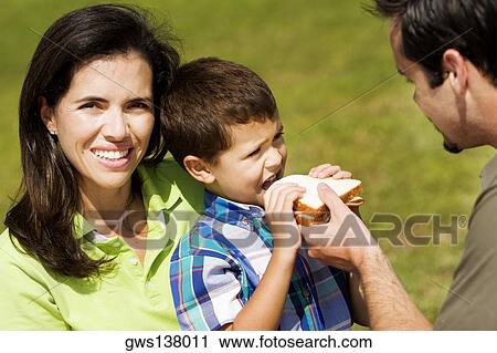 Close-up of a father feeding his son a sandwich View Large Photo Image Stock Image - Close-up of a father feeding his son a sandwich. Fotosearch
