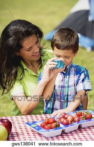 Close-up of a mother feeding her son with a bottle View Large Photo Image Stock Image - Close-up of a mother feeding her son with a bottle. Fotosearch