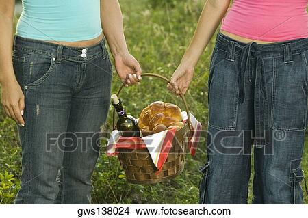 Mid section view of two women holding a picnic basket View Large Photo Image Picture - Mid section view of two women holding a picnic basket. Fotosearch