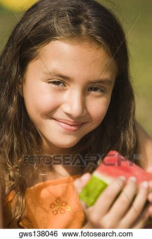 Portrait of a girl holding a slice of a watermelon View Large Photo Image Stock Photograph - Portrait of a girl holding a slice of a watermelon. Fotosearch