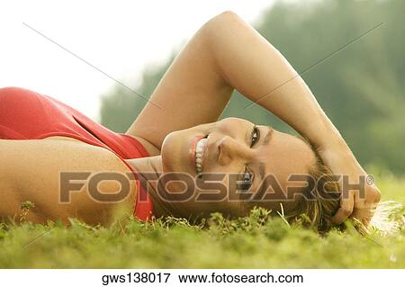 Portrait of a mature woman lying on the grass View Large Photo Image Stock Photo - Portrait of a mature woman lying on the grass. Fotosearch
