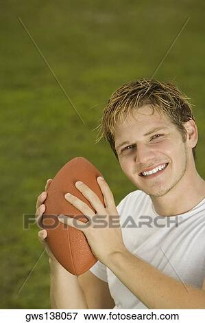 Portrait of a young man holding a rugby ball View Large Photo Image Stock Photo - Portrait of a young man holding a rugby ball. Fotosearch