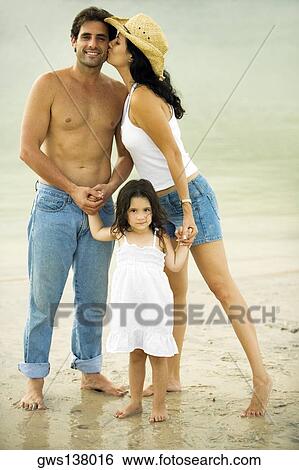 Portrait of a young woman kissing a mid adult man and her daughter on the beach View Large Photo Image Stock Photograph - Portrait of a young woman kissing a mid adult man and her daughter on the beach. Fotosearch