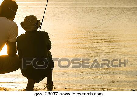 Stock Photo - Rear view of a father and his son fishing. Fotosearch