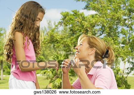 Side profile of a mother and her daughter facing each other View Large Photo Image Stock Photograph - Side profile of a mother and her daughter facing each other. Fotosearch