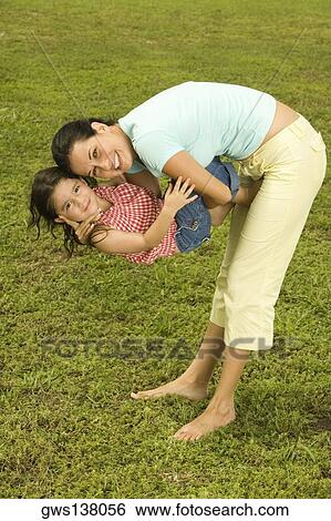 Side profile of a young woman holding her daughter View Large Photo Image Stock Photograph - Side profile of a young woman holding her daughter. Fotosearch
