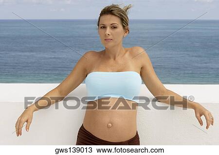 Portrait of a pregnant woman leaning against the wall View Large Photo Image Stock Image - Portrait of a pregnant woman leaning against the wall. Fotosearch