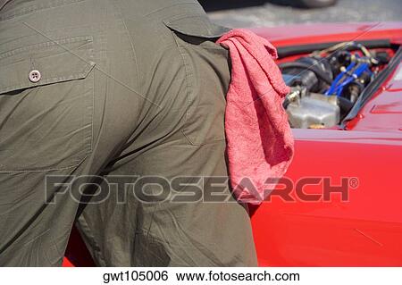 Stock Photograph - Mid section view of a mechanic near a car. Fotosearch
