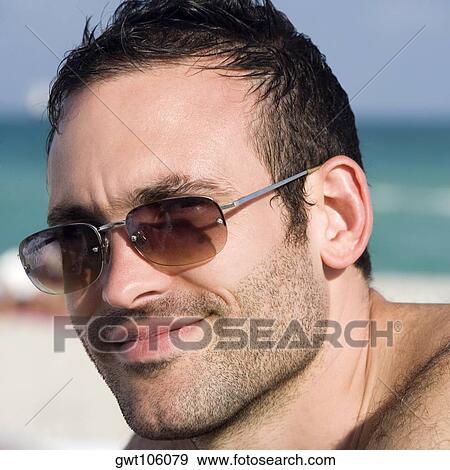 Close-up of a young man smiling View Large Photo Image Stock Photo - Close-up of a young man smiling. Fotosearch