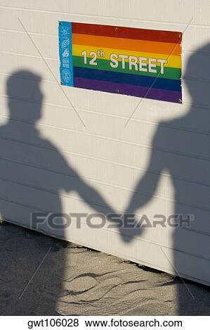 Stock Photo - Shadow of two people on a wall holding hands. Fotosearch