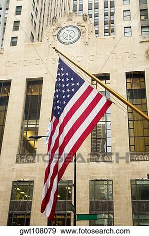 Stock Photo - Low angle view of the American flag in front of a building, Chicago Board Of Trade, Chicago, Illinois, USA. Fotosearch