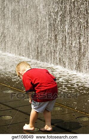 Rear view of a boy standing near a fountain, Chicago, Illinois, USA View Large Photo Image Stock Photo - Rear view of a boy standing near a fountain, Chicago, Illinois, USA. Fotosearch