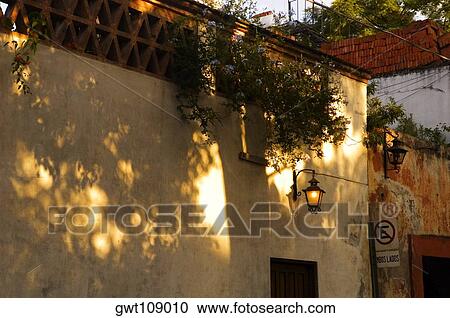 Stock Image - Lantern lit up on the wall of a building, Mexico. Fotosearch