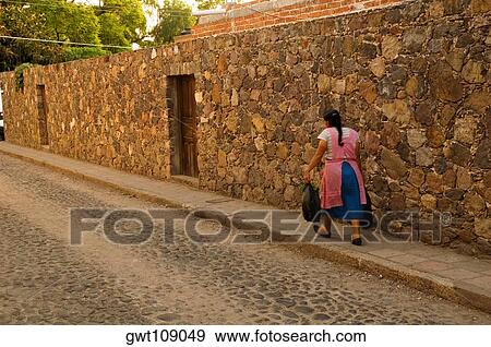 Rear view of a woman walking on a footpath, Mexico View Large Photo Image Stock Photo - Rear view of a woman walking on a footpath, Mexico. Fotosearch