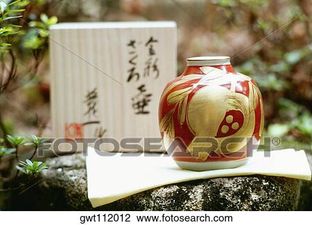 Stock Image - Close-up of a vase and a napkin on a rock, Kyoto, Japan. Fotosearch