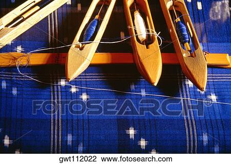 Stock Image - Weaver's bobbins on indigo fabric, Matsuyama, Japan. Fotosearch