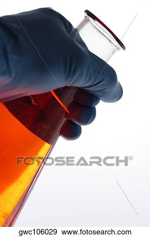 Stock Photo - Close-up of a beaker in a person's hand. Fotosearch