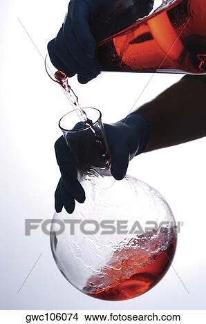 Close-up of a person pouring chemicals into a beaker View Large Photo Image Picture - Close-up of a person pouring chemicals into a beaker. Fotosearch