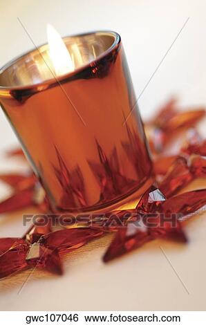 Close-up of a lit candle in a glass with star shaped Christmas ornaments around it View Large Photo Image Stock Photograph - Close-up of a lit candle in a glass with star shaped Christmas ornaments around it. Fotosearch