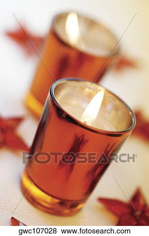 Stock Photo - High angle view of lit candles in glasses. Fotosearch